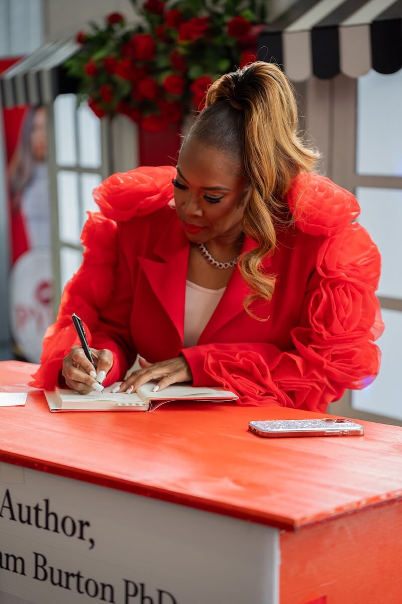 Karmetria singing Never Wear Red Lipstick book at event