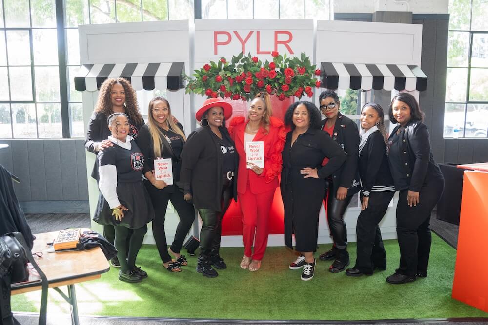 Karmetria posing with books and 8 guests at Paint Your Lips Red Event