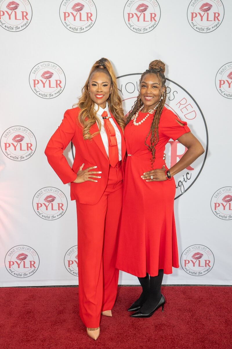 Karmetria with guest smiling at Paint Your Lips Red Event
